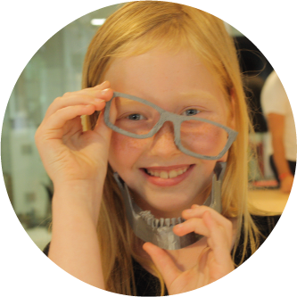 Una niña divirtiéndose con las gafas que imprimió en 3D.