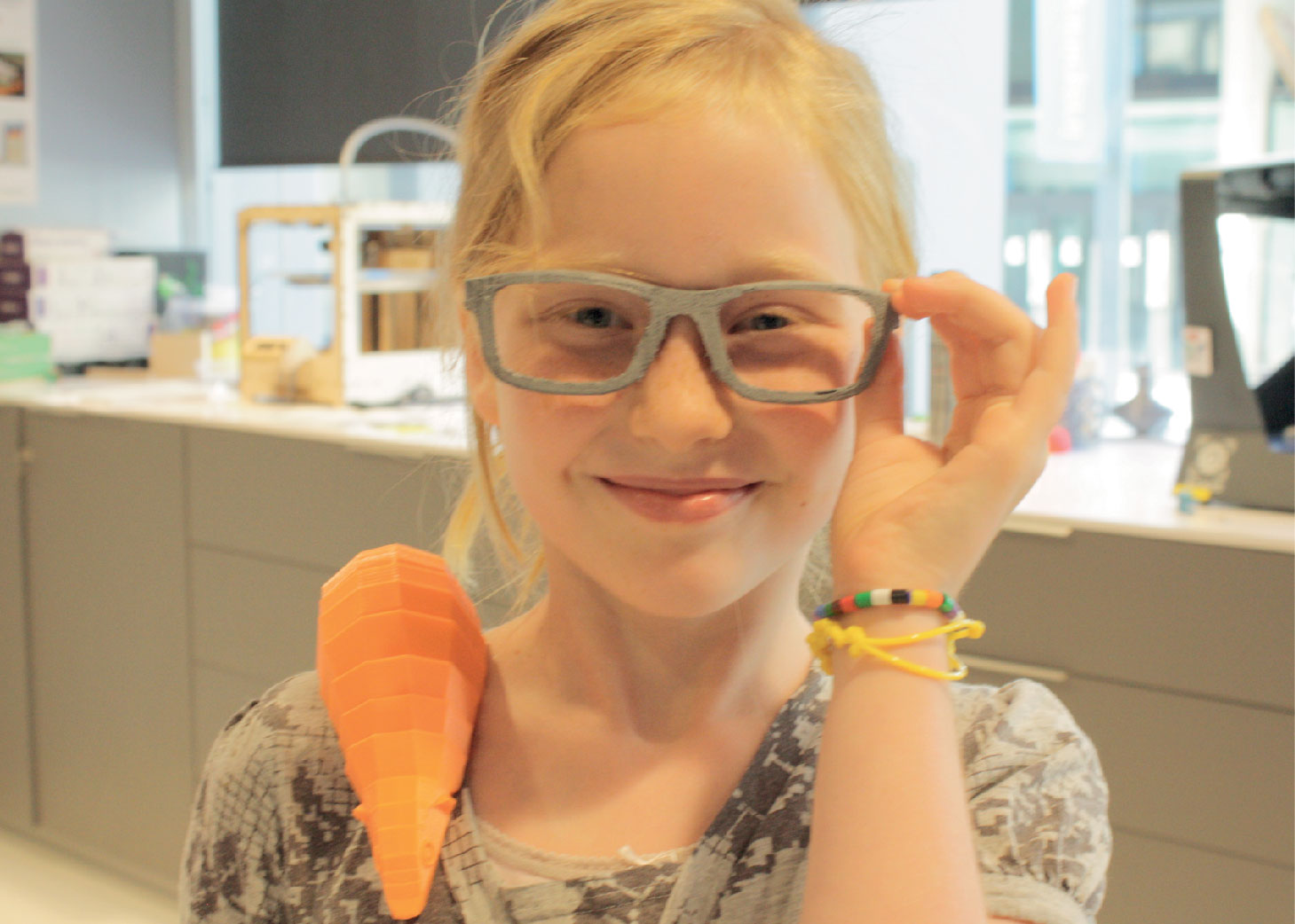 Una niña que sonríe y usa gafas impresas en 3d.